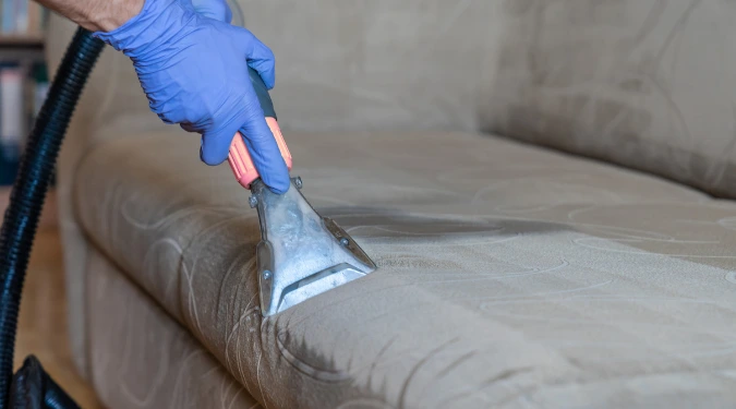 Man steam cleaning sofa