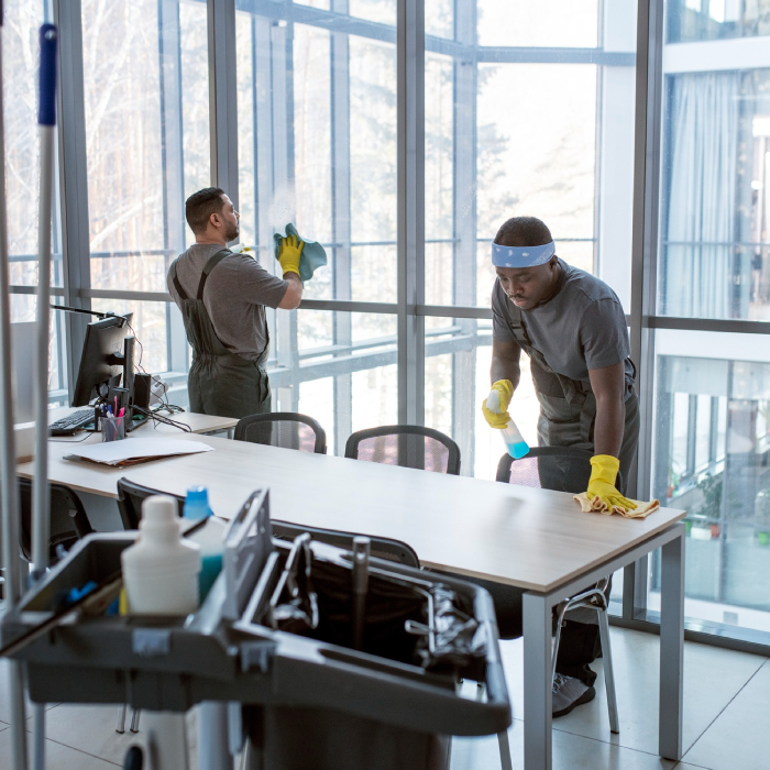 Office cleaner wiping glass windows with microfiber cloth